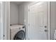 Clean laundry area featuring a modern front-load washing machine and white door at 4542 W Villa Theresa Dr, Glendale, AZ 85308