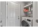 Well-organized laundry room with front load washer, shelving, and storage space at 4542 W Villa Theresa Dr, Glendale, AZ 85308