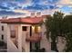 Two-story stucco building with red tile roofs, balconies, and a tree at 455 S Delaware Dr # 154, Apache Junction, AZ 85120