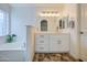 Modern bathroom with a double vanity, large mirror, and bathtub at 5153 W Pontiac Dr, Glendale, AZ 85308