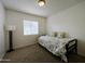 Cozy bedroom with carpet flooring, a modern lamp, and large window with bright sunlight streaming in at 5153 W Pontiac Dr, Glendale, AZ 85308