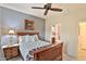 Bedroom with wooden bed frame, ensuite bathroom and ceiling fan at 5251 W Posse Dr, Eloy, AZ 85131