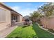 Expansive backyard featuring a covered patio, artificial turf, and lush landscaping at 5724 S Coyote Cyn, Mesa, AZ 85212