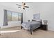 Bedroom featuring a ceiling fan, a large window with blinds and gray curtains, and a queen bed at 5724 S Coyote Cyn, Mesa, AZ 85212