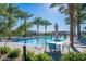 Serene community pool featuring relaxing lounge chairs and tables surrounded by lush greenery and palm trees at 5724 S Coyote Cyn, Mesa, AZ 85212