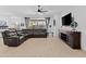 Bright living room featuring a ceiling fan, sectional couch, and sliding glass doors to the patio at 5724 S Coyote Cyn, Mesa, AZ 85212