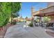 Covered patio with seating area, lush lawn, and mature trees at 6282 W Rose Garden Ln, Glendale, AZ 85308