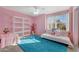 Pink bedroom with a daybed, built-in shelving, and a teal rug at 6282 W Rose Garden Ln, Glendale, AZ 85308