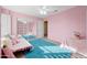 Pink bedroom with a daybed, mirrored closet doors, and a teal rug at 6282 W Rose Garden Ln, Glendale, AZ 85308