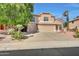 Two-story house with tan exterior, three car garage, and landscaped yard at 6282 W Rose Garden Ln, Glendale, AZ 85308