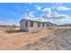 Tan home with grey trim, deck, and large yard at 645 S Warren Rd, Maricopa, AZ 85139