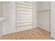 Walk-in closet with ample shelving and light wood floors at 6970 W Morning Dove Dr, Glendale, AZ 85308