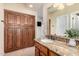 Bathroom with granite countertop, wooden cabinets, and large mirror at 7021 E Earll Dr # 213, Scottsdale, AZ 85251