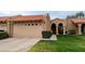 Tan stucco house with tile roof, two-car garage, and neatly landscaped front yard at 9103 E Winchcomb Dr, Scottsdale, AZ 85260