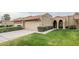 Tan stucco house with tile roof, two-car garage, and well-manicured lawn at 9103 E Winchcomb Dr, Scottsdale, AZ 85260