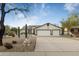 Two-car garage and xeriscaped front yard with rock and cacti at 9546 E Anasazi Pl, Gold Canyon, AZ 85118