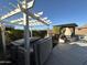 Backyard featuring a hot tub, outdoor kitchen with pizza oven, pergola and green landscaping at 9900 E Desert Trail Ln, Gold Canyon, AZ 85118