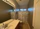 Well-lit bathroom featuring a vanity with double sinks and a shower with decorative curtain at 9900 E Desert Trail Ln, Gold Canyon, AZ 85118