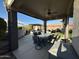 Spacious covered patio with outdoor dining furniture, ceiling fan, with a backyard and outdoor kitchen at 9900 E Desert Trail Ln, Gold Canyon, AZ 85118