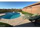 An in-ground pool with lounge chairs, artificial grass, and desert landscaping in the backyard at 9900 E Desert Trail Ln, Gold Canyon, AZ 85118