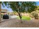 Landscaped backyard with artificial turf, trees, and play area at 1078 W Spur Ct, Gilbert, AZ 85233