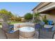Round fire pit surrounded by wicker chairs in backyard at 1078 W Spur Ct, Gilbert, AZ 85233