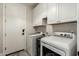 Bright laundry room featuring washer, dryer, and upper cabinets at 1078 W Spur Ct, Gilbert, AZ 85233