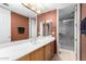 Bathroom with wood cabinets, marble shower, and updated fixtures at 14829 N 18Th Pl, Phoenix, AZ 85022