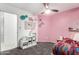Charming bedroom featuring pink accent wall, storage, and soft carpet for comfort at 15348 W Banff Ln, Surprise, AZ 85379
