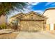 Tan house with a two-car garage and landscaping at 15348 W Banff Ln, Surprise, AZ 85379