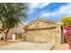 Tan house with a two-car garage and landscaping at 15348 W Banff Ln, Surprise, AZ 85379