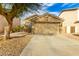 Tan house with a two-car garage and landscaping at 15348 W Banff Ln, Surprise, AZ 85379