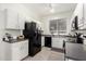 Modern kitchen with white cabinets and black appliances at 15348 W Banff Ln, Surprise, AZ 85379