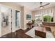 Gathering room with L-shaped sofa, dark wood floors, and a large TV at 18111 W Desert Sage Dr, Goodyear, AZ 85338