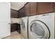 Well-equipped laundry room with washer, dryer, and cabinets at 18111 W Desert Sage Dr, Goodyear, AZ 85338