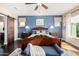 Main bedroom with a wooden sleigh bed, and barn door to en suite at 18111 W Desert Sage Dr, Goodyear, AZ 85338