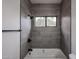 Updated bathroom with gray tile and bathtub shower at 18429 N 16Th Way, Phoenix, AZ 85022