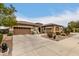 Tan two-story house with three-car garage and desert landscaping at 19000 E Old Beau Trl, Queen Creek, AZ 85142