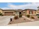 Tan two-story house with three-car garage and desert landscaping at 19000 E Old Beau Trl, Queen Creek, AZ 85142