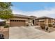 Tan two-story house with three-car garage and desert landscaping at 19000 E Old Beau Trl, Queen Creek, AZ 85142