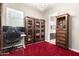 Home office with built-in storage and a red carpet at 19000 E Old Beau Trl, Queen Creek, AZ 85142