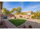 This backyard is a peaceful retreat with a green lawn, mature trees, and rock landscaping at 2036 E Stacey Rd, Gilbert, AZ 85298