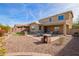 This backyard boasts a spacious patio with a fire pit, and low-maintenance desert landscaping at 2036 E Stacey Rd, Gilbert, AZ 85298