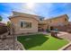 This backyard features a green lawn, stone perimeter, and a patio with comfortable seating at 2036 E Stacey Rd, Gilbert, AZ 85298