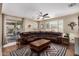 The open concept living room features a large leather sofa, stylish ceiling fan, and sliding glass doors to the patio at 2036 E Stacey Rd, Gilbert, AZ 85298