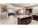 Open-concept living space flows from the kitchen with island to the living area with leather sofa and staircase at 2036 E Stacey Rd, Gilbert, AZ 85298
