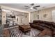 Spacious living room with a cozy leather sectional, stylish rug, and seamless access to dining and kitchen at 2036 E Stacey Rd, Gilbert, AZ 85298