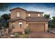 Two-story house with a brown facade, brick driveway, and desert landscaping at 21408 E Sparrow Dr, Queen Creek, AZ 85142