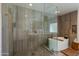 Luxurious bathroom with glass shower, modern soaking tub, and tiled walls at 3601 N 55Th Pl, Phoenix, AZ 85018