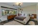 Bright bedroom featuring a mid-century dresser, stylish decor, and a large window with a lush green view at 3601 N 55Th Pl, Phoenix, AZ 85018